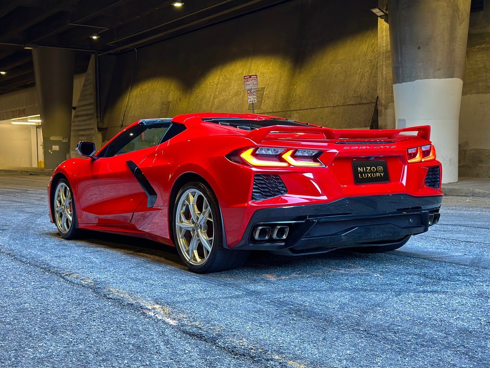 Red Corvette Convertible parked in a concrete structure with the roof down