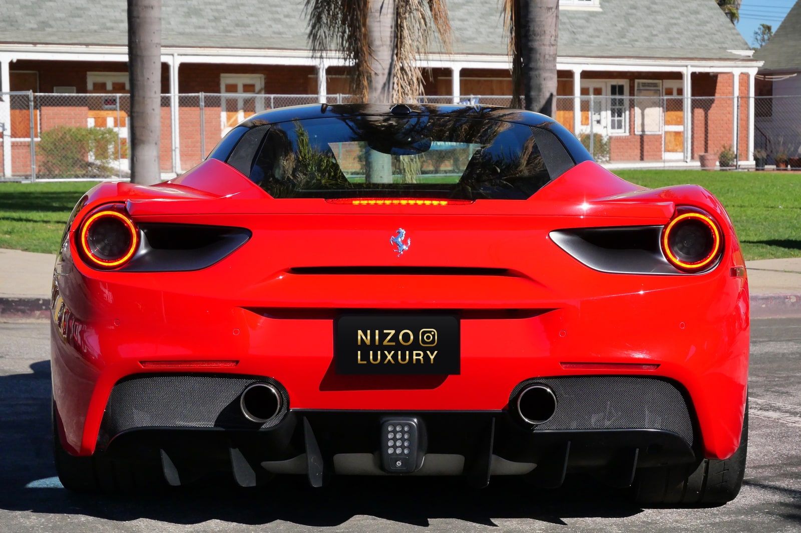 Rear view of the red Ferrari 488 GTB with round tail lights and quad exhausts