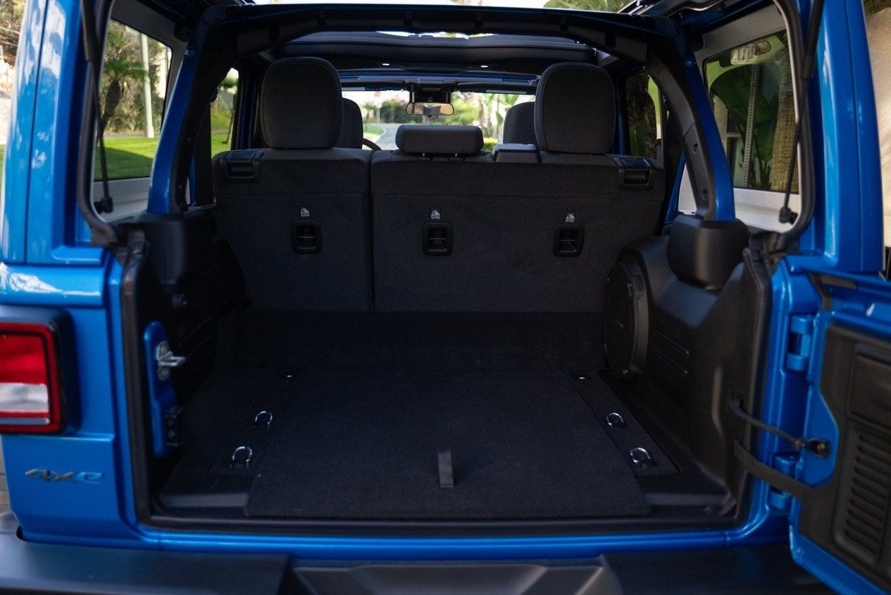 Rear cargo area of a Jeep Wrangler with the rear seats up, showing the shallow shelf left behind them