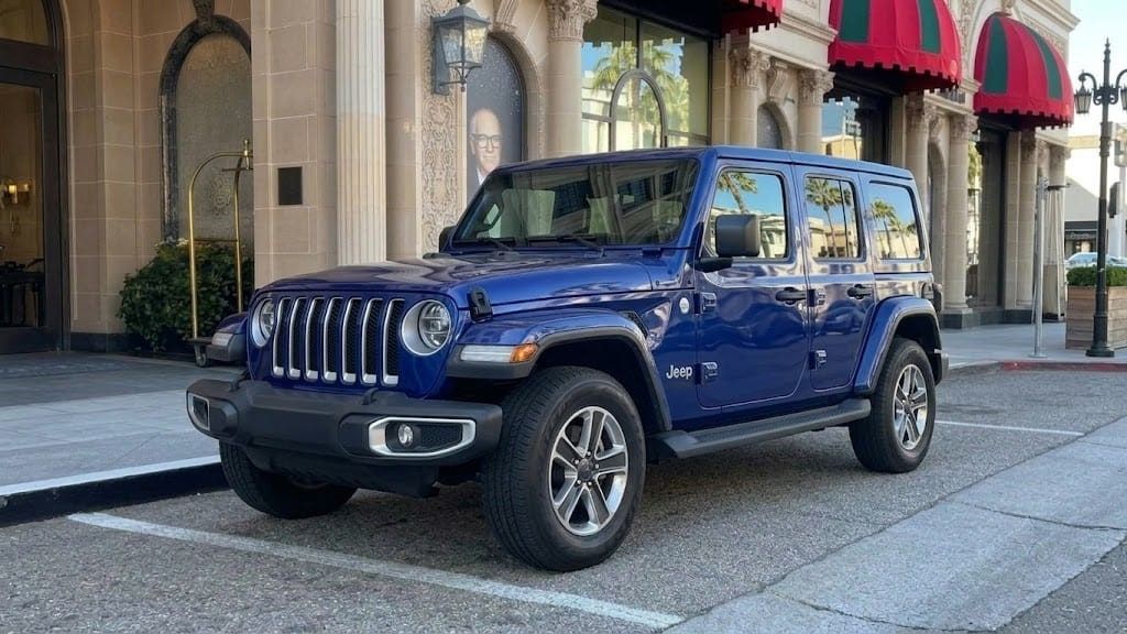 Blue Jeep Wrangler at a Beverly Hills kerb, its ground clearance visible under the body