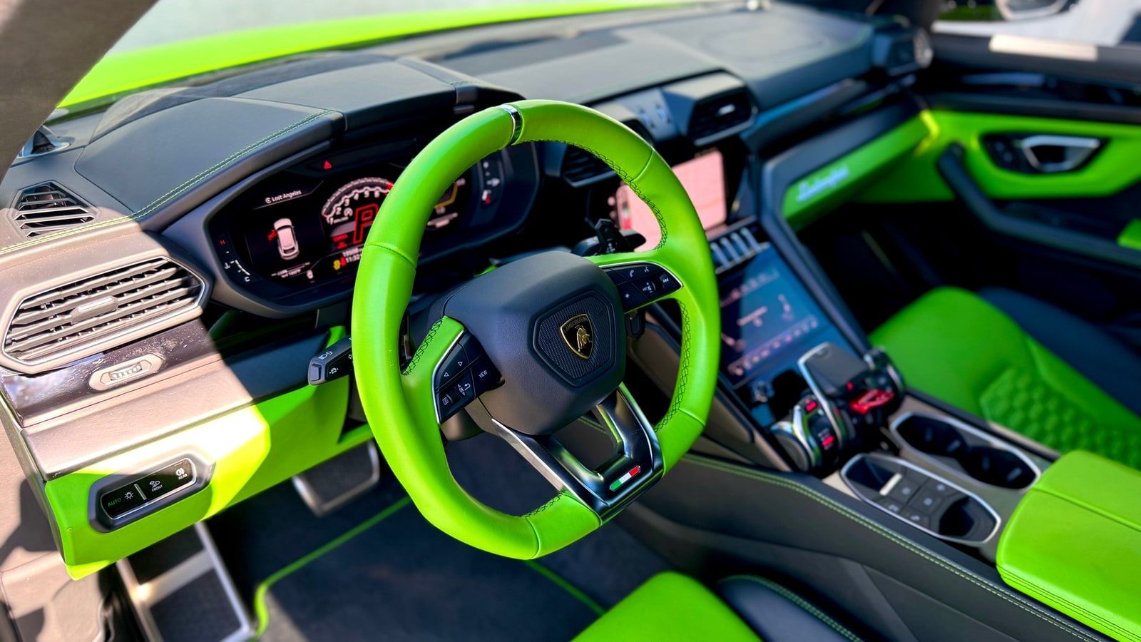 Green leather steering wheel of the Lamborghini Urus with the crest on the boss