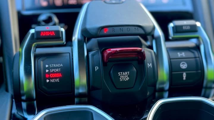 The tamburo drive selector and red start cover in a Lamborghini Urus