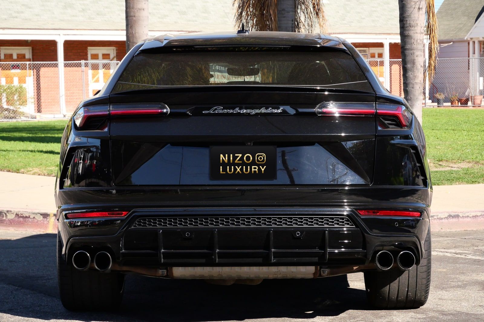 Rear of the black Lamborghini Urus with the Lamborghini script and quad exhausts