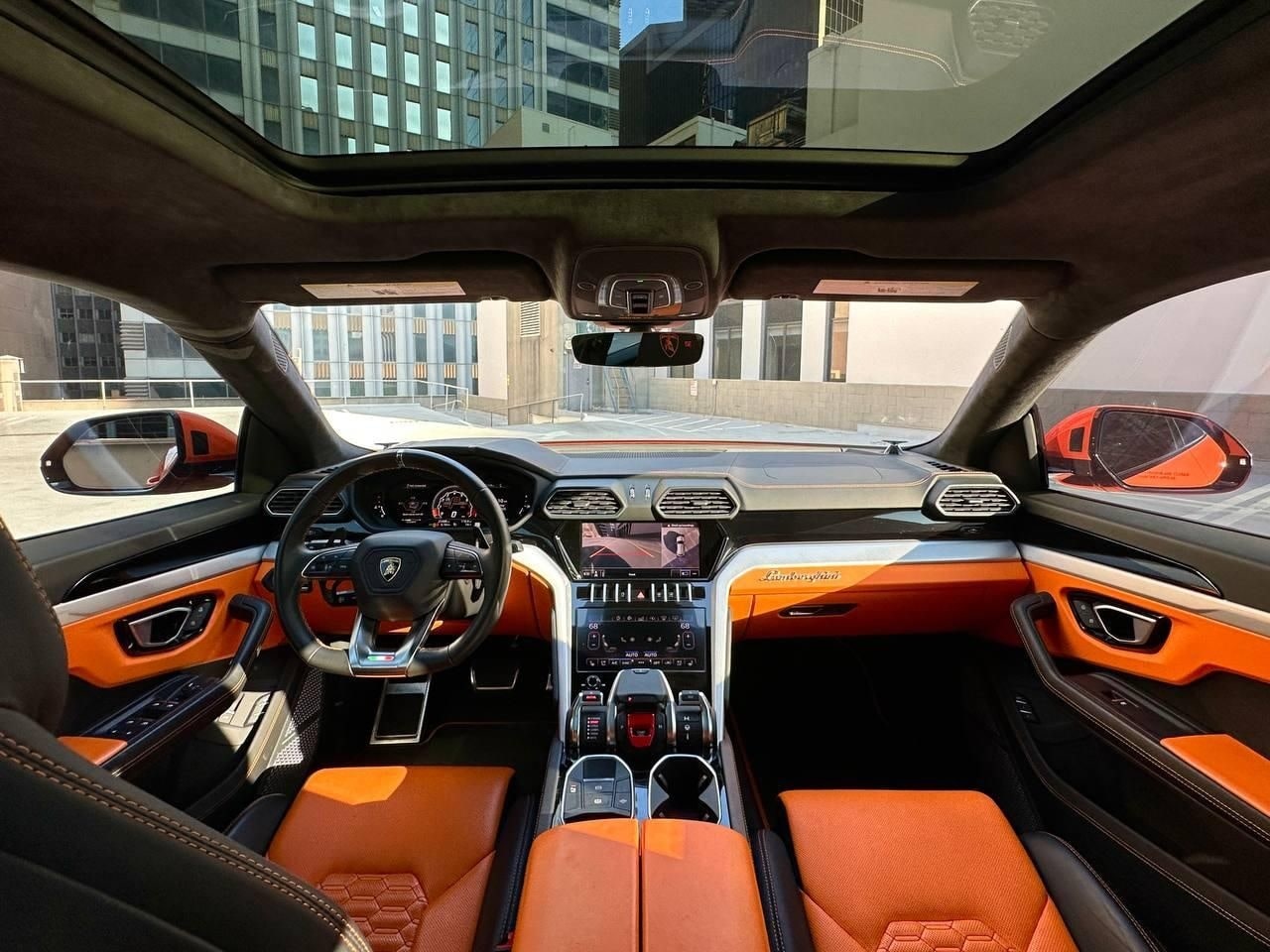 Orange and black cabin of the Lamborghini Urus seen through the open door