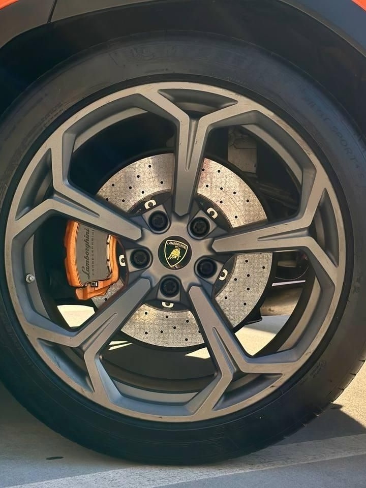 Grey wheel and orange brake caliper on the orange Lamborghini Urus