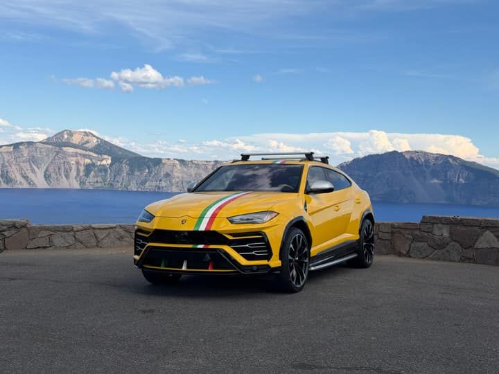 Yellow Lamborghini Urus parked at a mountain overlook