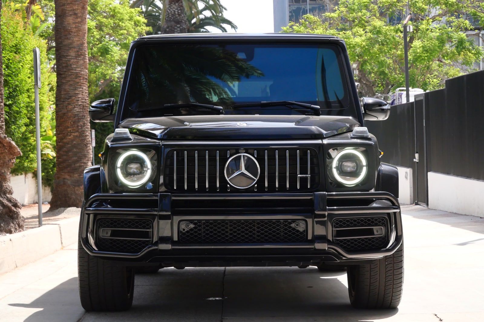 Black Mercedes-AMG G 63 head-on with round LED headlights and the star grille