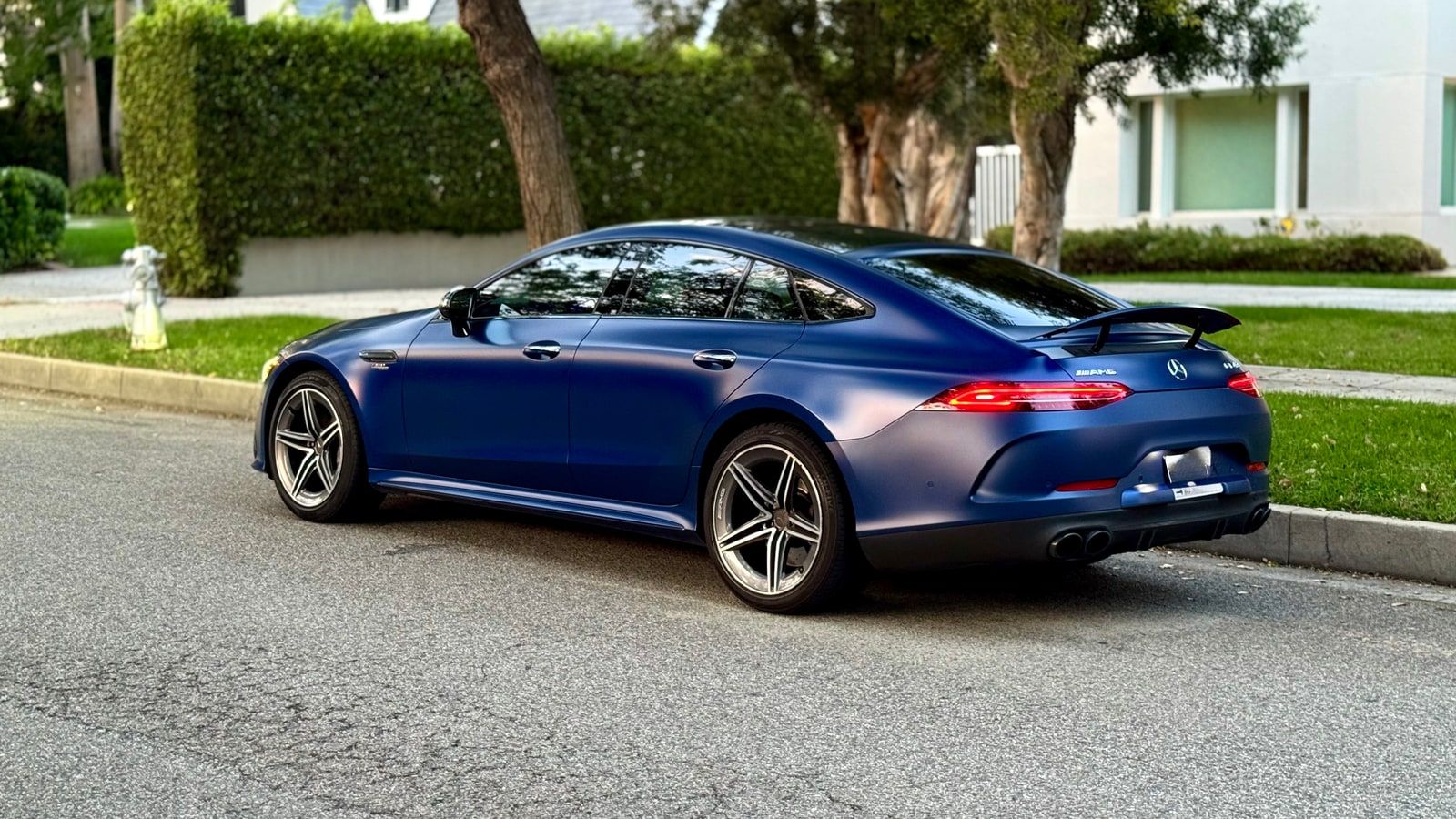 Blue Mercedes-AMG GT 43 four-door coupe in profile on a Los Angeles street