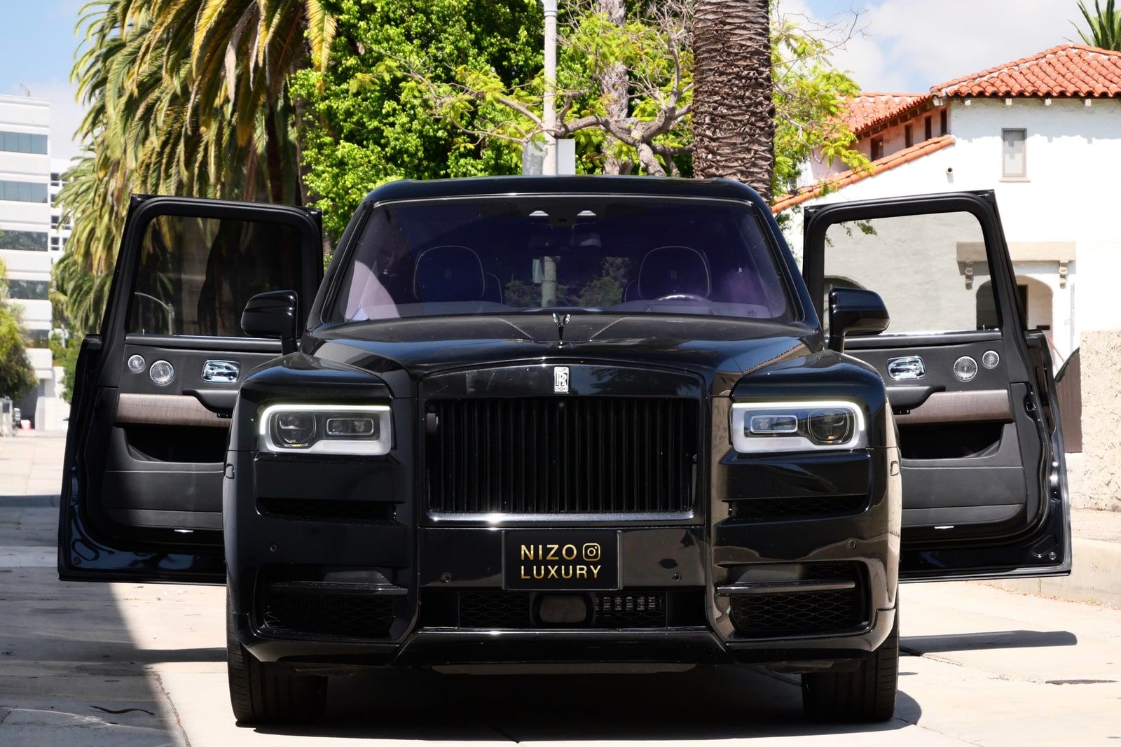 Black Rolls-Royce Cullinan with both coach doors open on a Beverly Hills street