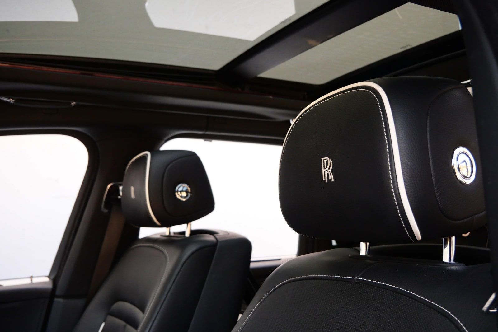 Panoramic glass roof above embroidered Rolls-Royce headrests in the Cullinan