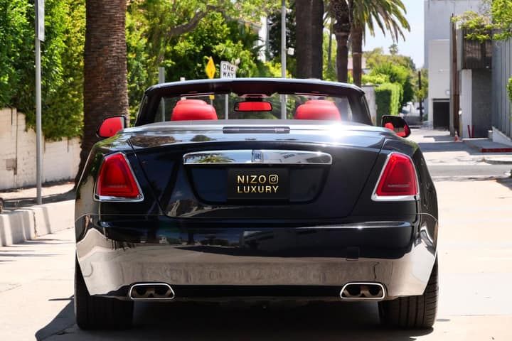 Rear view of a black Rolls-Royce Dawn convertible with the roof down