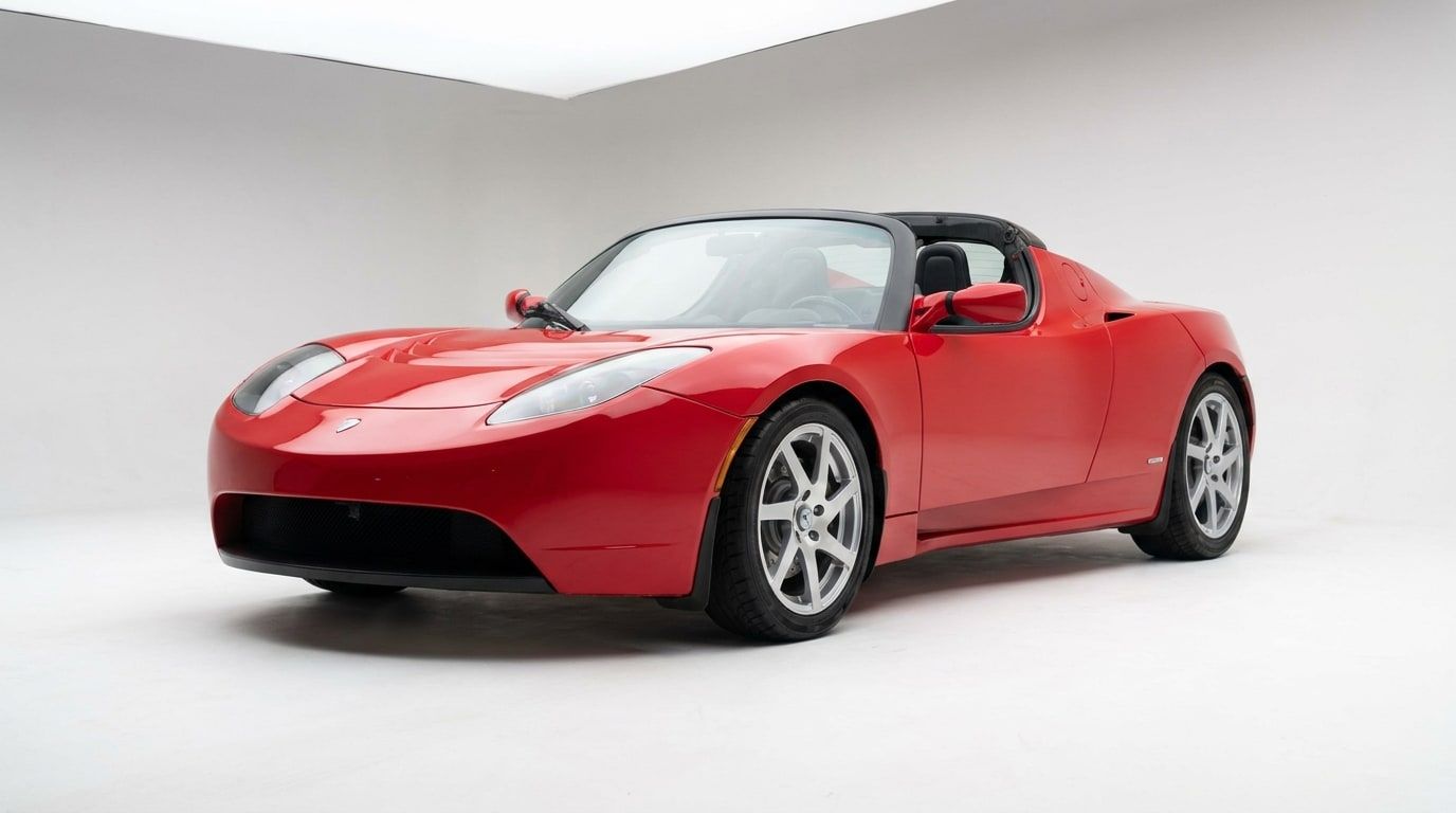 Red 2008 Tesla Roadster in a white studio, low front three-quarter view
